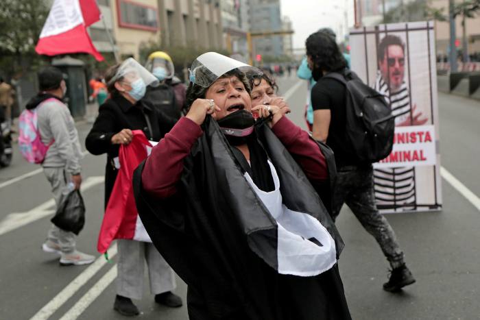 Una mujer grita consignas durante una protesta contra Pedro Castillo el día de la inauguración en Lima