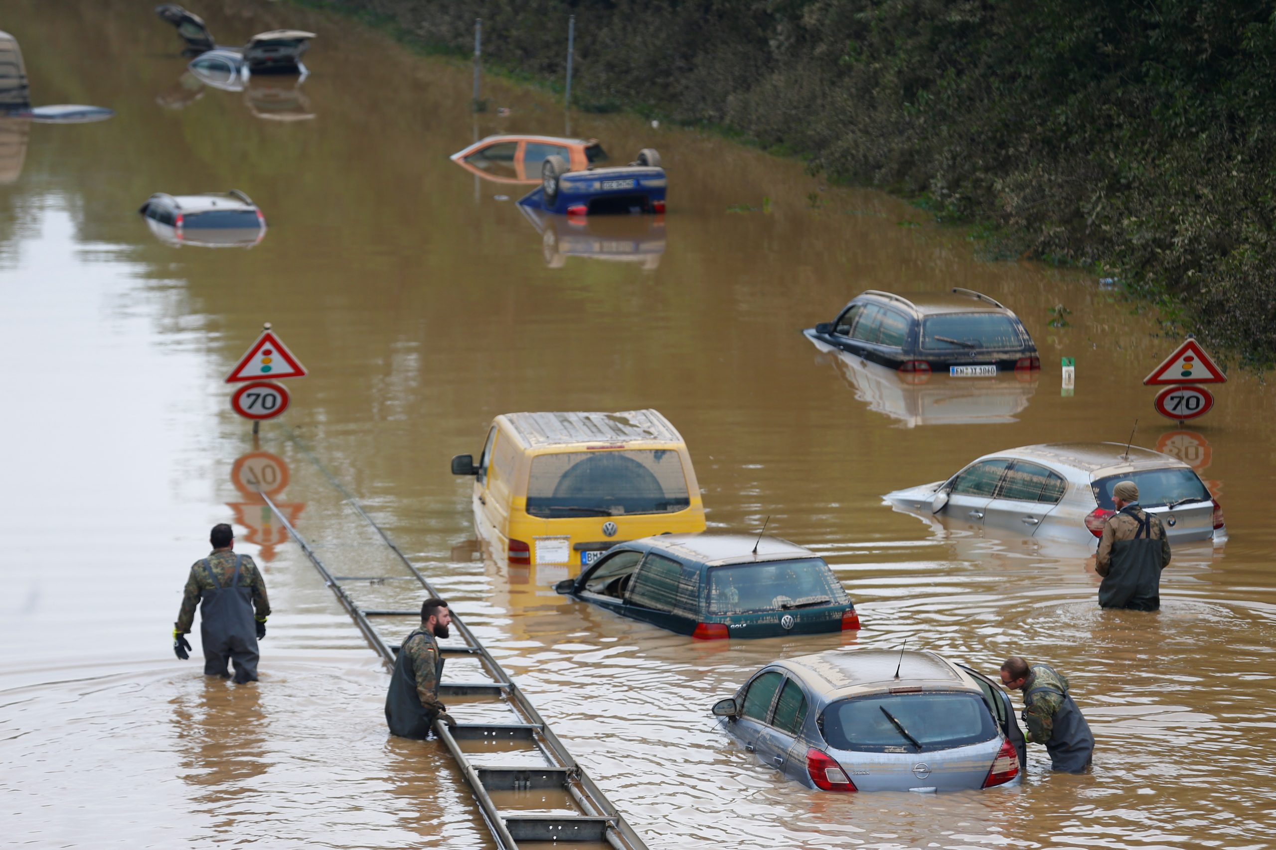 Los miembros de las fuerzas de la Bundeswehr, rodeados por automóviles parcialmente sumergidos, atraviesan el agua de la inundación después de las fuertes lluvias en Erftstadt-Blessem, Alemania, el 17 de julio de 2021. REUTERS / Thilo Schmuelgen