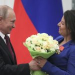 El presidente ruso, Vladimir Putin, presenta a la editora en jefe de RT, Margarita Simonyan, un ramo de flores.