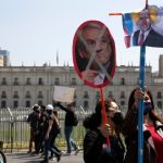 Maestros que protestan contra el gobierno de Chile sostienen carteles que representan al presidente Sebastián Piñera