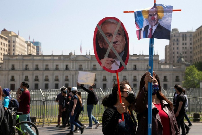 Maestros que protestan contra el gobierno de Chile sostienen carteles que representan al presidente Sebastián Piñera