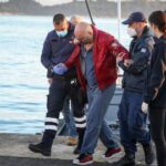 Un pasajero rescatado llega al puerto de Corfú el viernes, luego de que cientos fueran evacuados del barco.