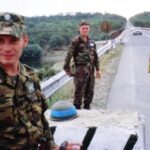 Un oficial ruso (izquierda), un soldado moldavo (centro) y un soldado de Transnistria (derecha) montan guardia en la zona de seguridad que separa Moldavia y Transnistria a lo largo del río Dniéster, en 2002.