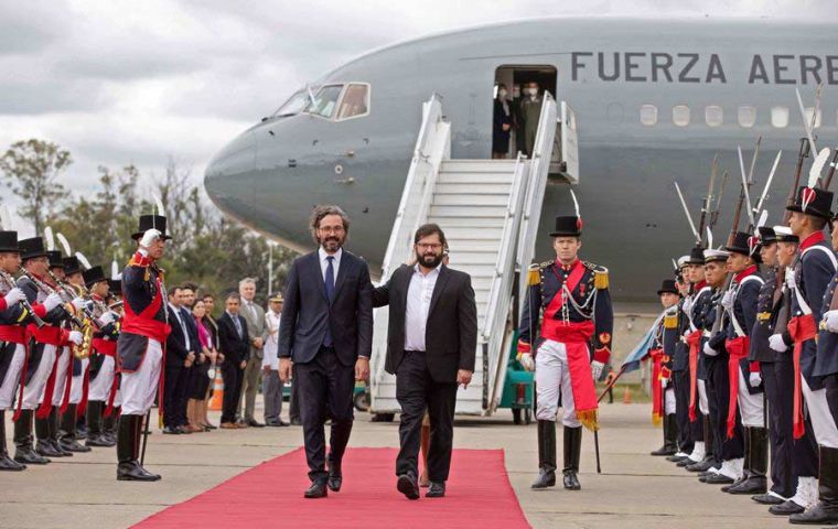 El presidente Gabriel Boric (CR) camina junto al canciller argentino Santiago Cafiero a su llegada a Buenos Aires