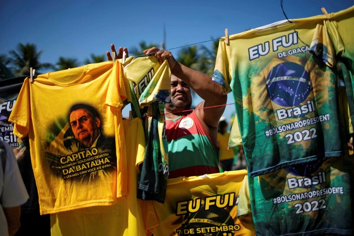 Un vendedor cuelga camisetas del presidente brasileño Jair Bolsonaro en mayo de 2022