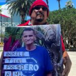 Alex Henríquez, migrante salvadoreño de 55 años, sostiene una fotografía de su hermano, quien estuvo preso por el régimen de Nayib Bukele