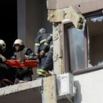 Los equipos de rescate evacuan a una persona de un edificio residencial dañado por un ataque con misiles rusos en Kyiv, Ucrania, el 26 de junio de 2022.
