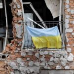 Una bandera nacional ucraniana cuelga del balcón de un edificio civil destruido en Irpin, Ucrania, el 16 de junio de 2022.