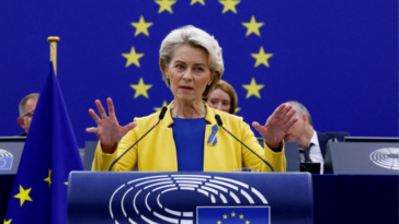 Ursula von der Leyen de pie en un atril, la estrella de la UE detrás de ella