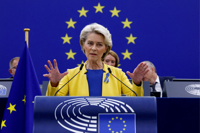 Ursula von der Leyen de pie en un atril, la estrella de la UE detrás de ella