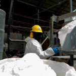 Un trabajador usa una pala para almacenar carbonato de litio en una bolsa en la planta piloto de Llipi en el salar de Uyuni en agosto.