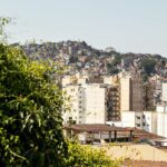 Fotografía de un paisaje urbano montañoso con tejados inclinados de terracota y bloques de viviendas