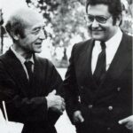 Dos hombres con traje charlan en una foto en blanco y negro