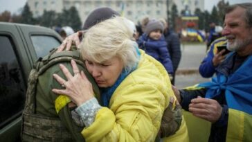 Un residente local abraza a un militar ucraniano mientras la gente celebra la retirada de Rusia de la ciudad de Kherson, en el centro de Kherson, Ucrania, el 12 de noviembre de 2022.