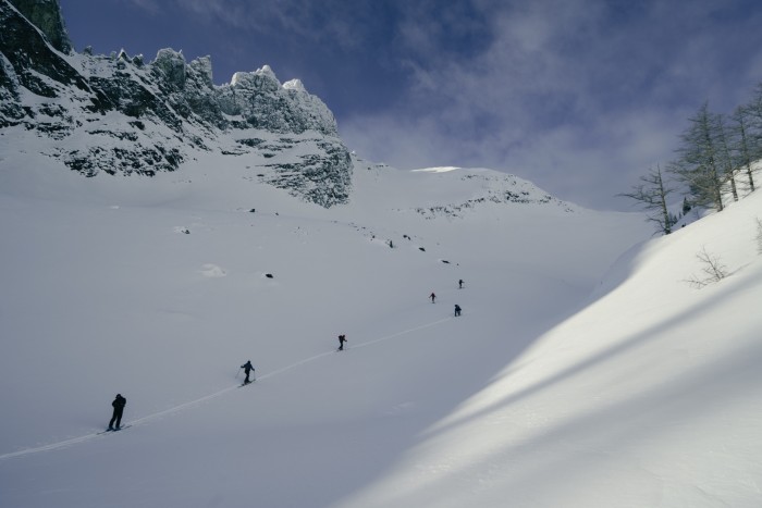 Figuras vistas en un valle nevado bajo un cielo azul