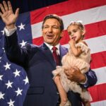 El gobernador republicano de Florida, Ron DeSantis, sostiene a su hija durante una fiesta de la noche de las elecciones en Florida.