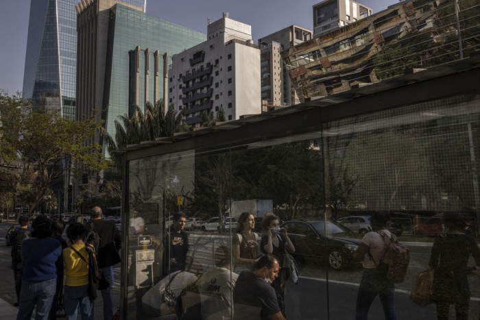 Los peatones esperan en una parada de autobús en Sao Paulo, Brasil.