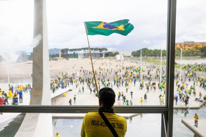 Un hombre ondea la bandera de Brasil mientras los partidarios del expresidente brasileño Jair Bolsonaro se manifiestan contra el presidente Luiz Inacio Lula da Silva.