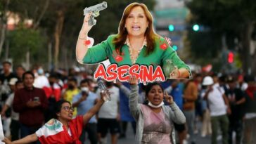 Un manifestante en Lima sostiene una representación de Dina Boluarte con la palabra 'asesina'.