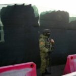 Un guardia fronterizo bielorruso vigila junto a una barricada hecha con neumáticos de camiones en el cruce fronterizo de Divin entre Bielorrusia y Ucrania en la región de Brest el 15 de febrero de 2023.