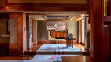 Una pintura de lo que parece una mano agarrando un corazón en la parte trasera de un pasillo modernista con paneles de madera.