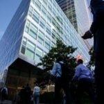 Trabajadores cruzan la calle en la sede de Goldman Sachs en Nueva York