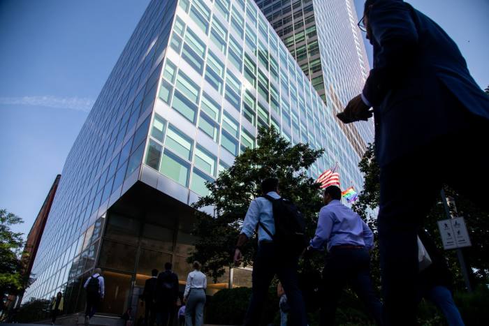 Trabajadores cruzan la calle en la sede de Goldman Sachs en Nueva York