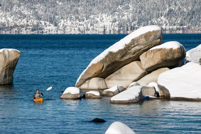 Kayak en Sand Harbor, en el lado de Nevada del lago Tahoe, en primavera con nieve en las rocas y la montaña