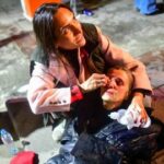 Una mujer afectada por gases lacrimógenos recibe asistencia médica durante un mitin contra el