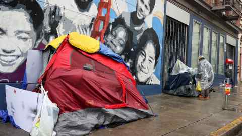 Se ven tiendas de campaña para personas sin hogar y una mujer sin hogar cerca del distrito de Tenderloin de la ciudad.