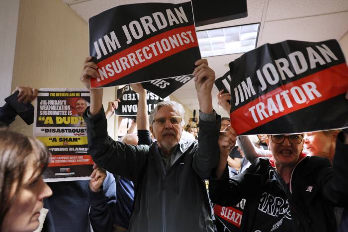 Los manifestantes sostienen carteles que denuncian a Jim Jordan, el miembro republicano de la Cámara que preside la audiencia del lunes.