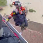 Esta foto proporcionada por la guardia costera italiana muestra a los rescatistas salvando a un hombre del techo de una casa inundada, en el área de la ciudad de Faenza.