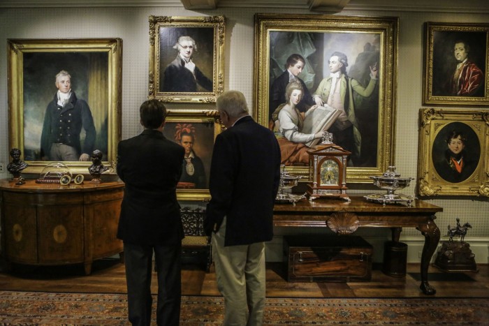 Harlan Crow, a la derecha, ve obras de arte con un invitado dentro de su residencia de Highland Park en Dallas, Texas.