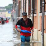 Un hombre vadea las aguas de la inundación en la ciudad de Lugo el viernes.  Los investigadores dicen que la devastación está relacionada con la crisis climática.
