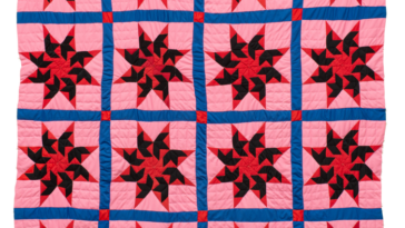 Una colcha rosa, morada y roja muestra 16 estrellas de ocho puntas dispuestas en un patrón de cuadrícula