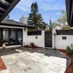 Una casa en blanco y negro con un soleado jardín estilo patio, $3.875mn