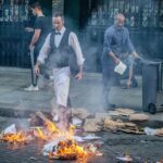 Empleados de restaurante intentan apagar un incendio durante una protesta en París el 30 de junio de 2023.