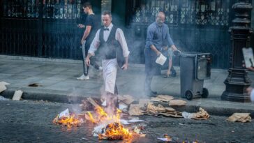 Empleados de restaurante intentan apagar un incendio durante una protesta en París el 30 de junio de 2023.