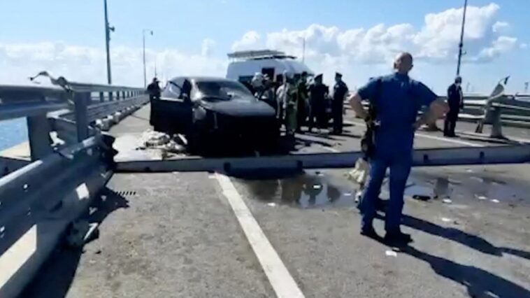 Los investigadores rusos se reúnen cerca de un automóvil destruido en la sección dañada del puente el 17 de julio de 2023.