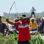 Un miembro de la comunidad indígena Yukpa armado con un arco y una flecha bloquea la carretera exigiendo hablar con María Corina Machado durante su viaje por carretera cerca de Maracaibo