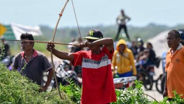 Un miembro de la comunidad indígena Yukpa armado con un arco y una flecha bloquea la carretera exigiendo hablar con María Corina Machado durante su viaje por carretera cerca de Maracaibo