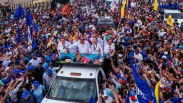El candidato presidencial Edmundo González y la líder opositora María Corina Machado saludan a sus partidarios desde la parte trasera de un camión durante un mitin de campaña en Maracaibo el martes