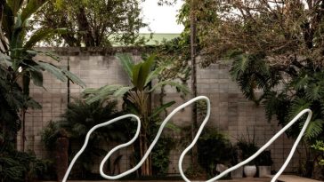 Piscina con una fina obra de arte ondulada en forma de tubo blanco que se arquea sobre ella