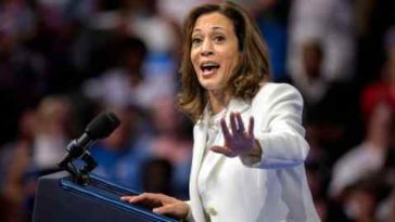 Kamala Harris habla en un mitin de campaña en Savannah, Georgia, el jueves 29 de agosto de 2024. Lleva un traje blanco y gesticula con una mano mientras está de pie detrás de un podio con micrófonos.