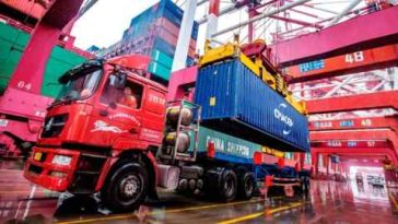 Un trabajador espera para transportar contenedores en el puerto de contenedores de Qingdao, en la provincia oriental china de Shandong.