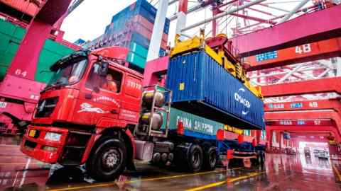 Un trabajador espera para transportar contenedores en el puerto de contenedores de Qingdao, en la provincia oriental china de Shandong.