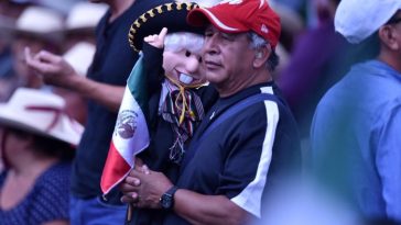 Un partidario del presidente López Obrador sostiene un muñeco que representa al presidente mexicano vestido de mariachi.