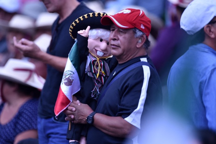 Un partidario del presidente López Obrador sostiene un muñeco que representa al presidente mexicano vestido de mariachi.