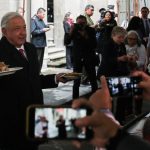 Un hombre que sostiene un plato de comida se enfrenta a una multitud de periodistas.