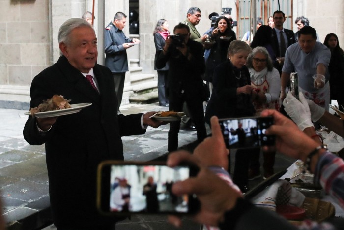 Un hombre que sostiene un plato de comida se enfrenta a una multitud de periodistas.